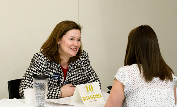 Photo of Beth Fischer speaking with a student