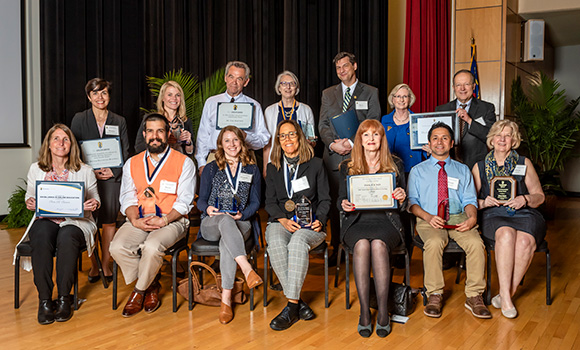 Group photo of faculty holding awards and certificates