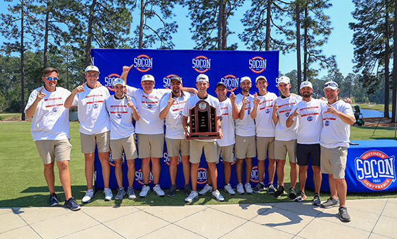 Photo of golf team posing with trophy