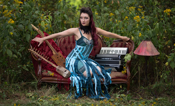 Photo of Crystal sitting on couch with musical instruments
