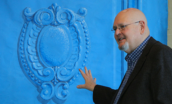 Photo of Joe Forbes in front of artwork