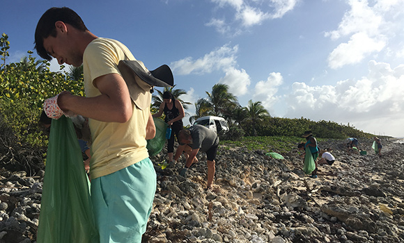 Photo of students picking up trash on beach