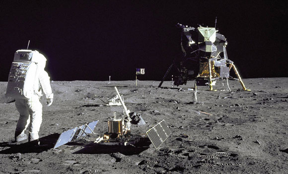 man walking on moon with craft in background