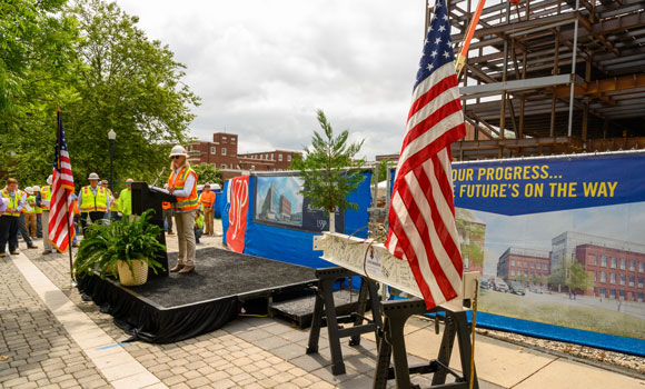 woman speaking at podium at construction site