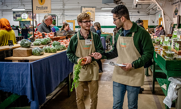 Photo of two men working at farmers market