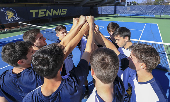 Photo of men's tennis team huddle on court