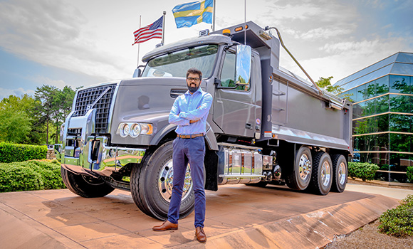 Photo of Dani Iqbal in front of large truck