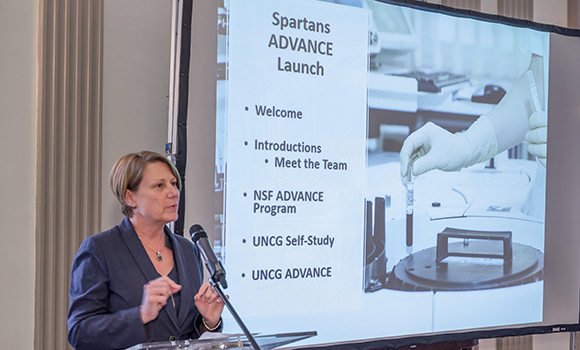 Photo of Provost Dunn speaking at podium with screen in background
