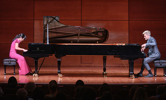 Piano duo performing on stage