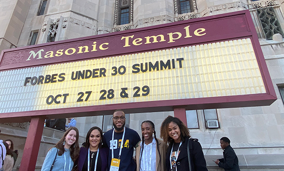students in front of the Masonic Temple in Detroit, Michigan under a marquee that reads: 