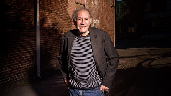 Portrait of Stuart Dischell with brick wall in background