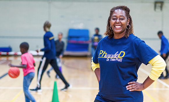 Photo of Trina Pratt in gym with kids playing in the background