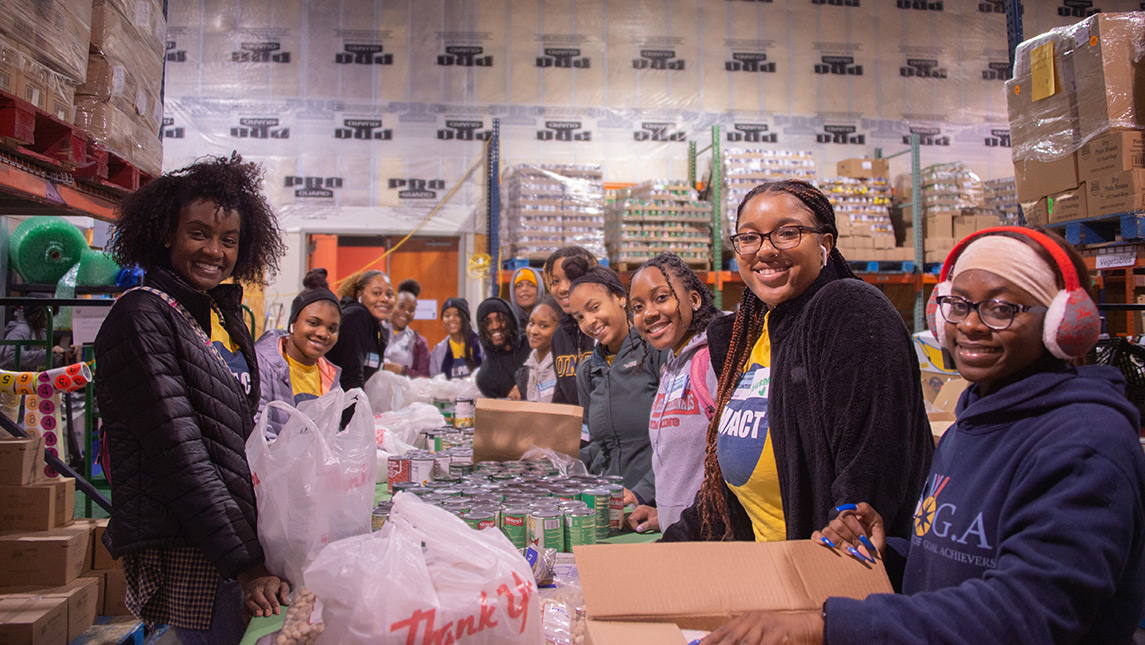 Students pose while bagging goods