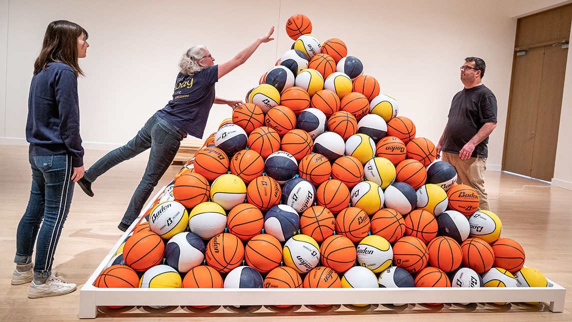 Photo of people assembling pyramid of basketballs