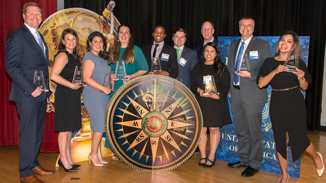Ten UNCG alumni honorees pose for a photo with their awards