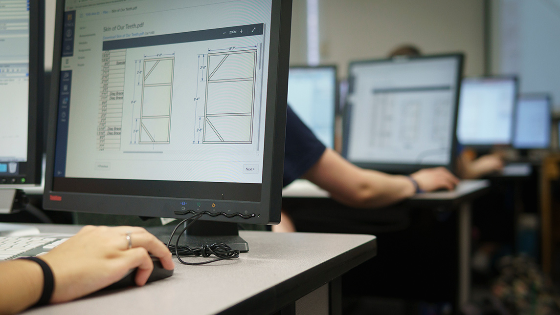 Rows of people working on computers in classroom setting