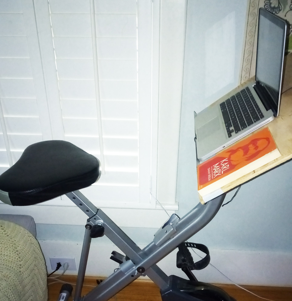Stationary bike with makeshift desk and computer
