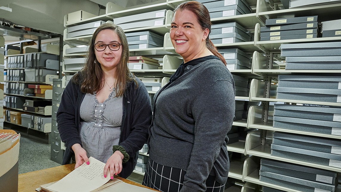 Abigail Knight with Erin Lawrimore looking at letters from President Foust from 1918