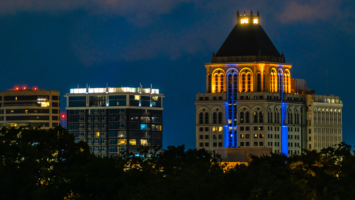 Greensboro skyline lit up with blue and gold