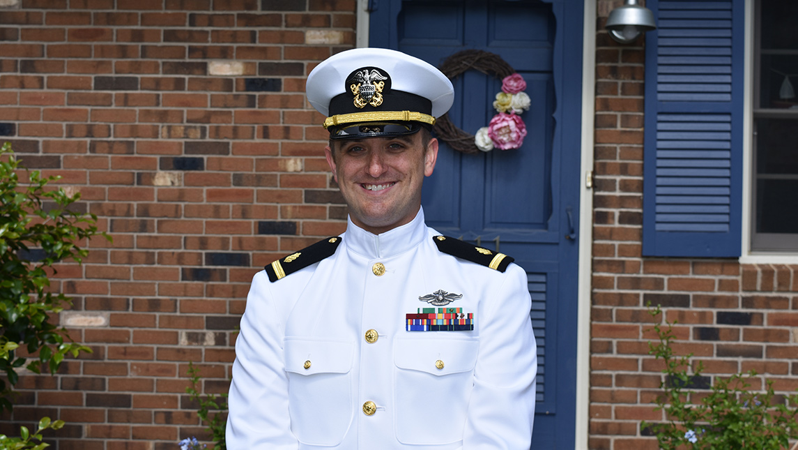 Photo of Navy Ensign Quinton Smith in front of house