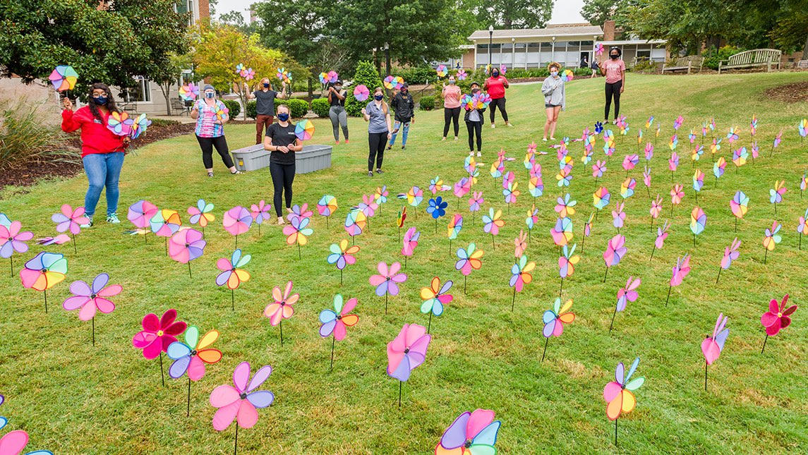 Students pose with the pinwheel display