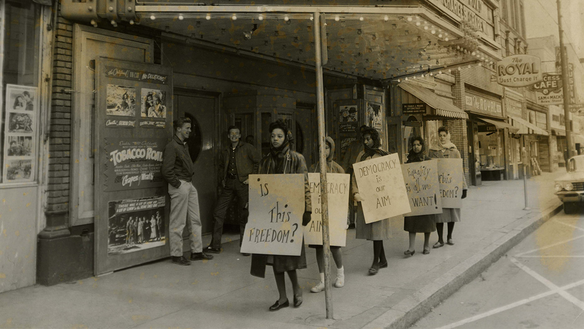 archival photo of women protesting on sidewalk