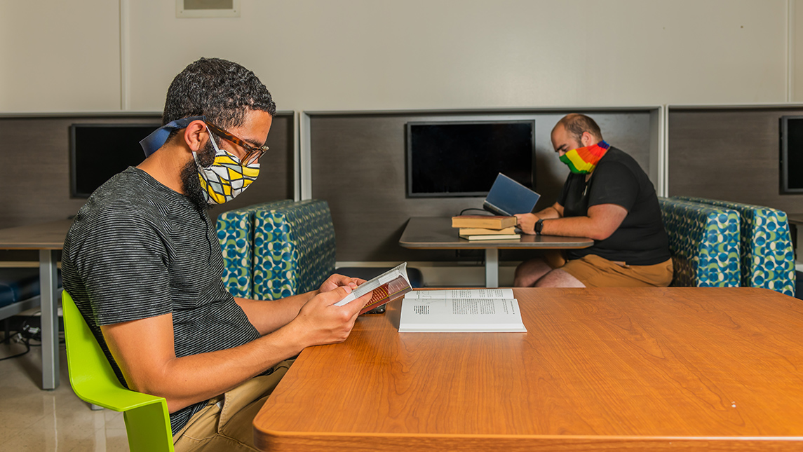 Students with face coverings studying in library