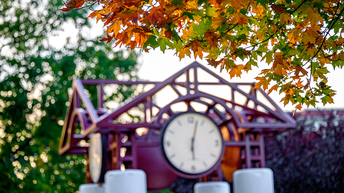 Photo of clock tower with fall foliage