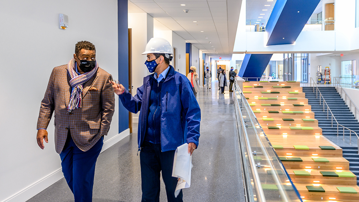 Photo of Chancellor talking to colleague in new building