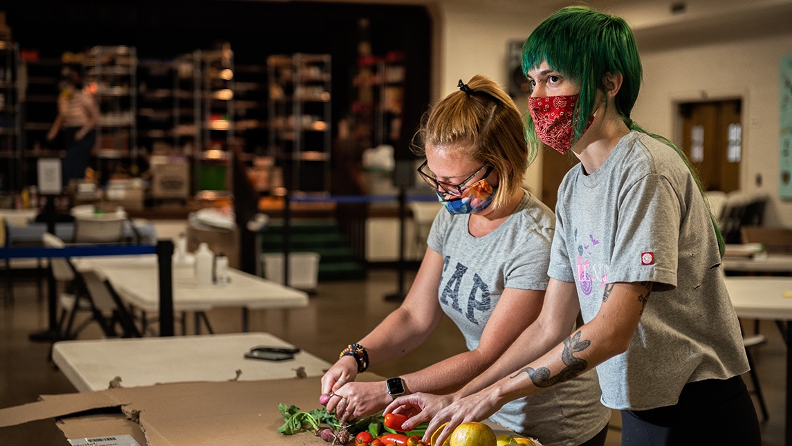Two students wearing masks chopping fresh vegetables at Spartan Open Pantry