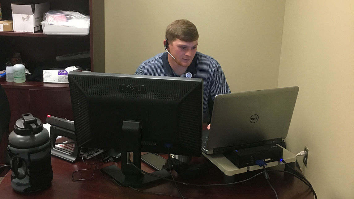 Aaron Sturdivant working in front of computers at his desk