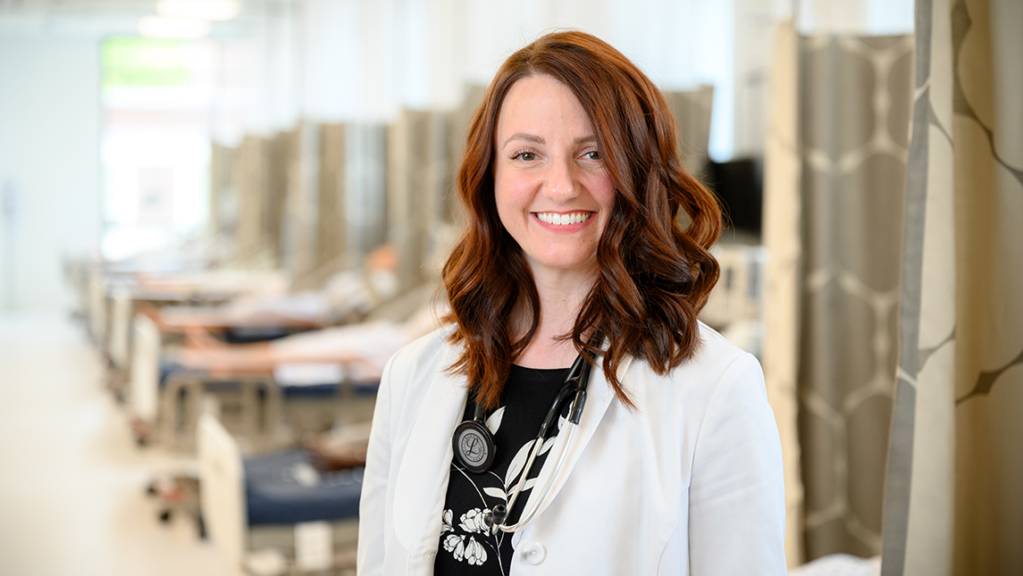 Photo of student in white nursing coat in nursing simulation lab