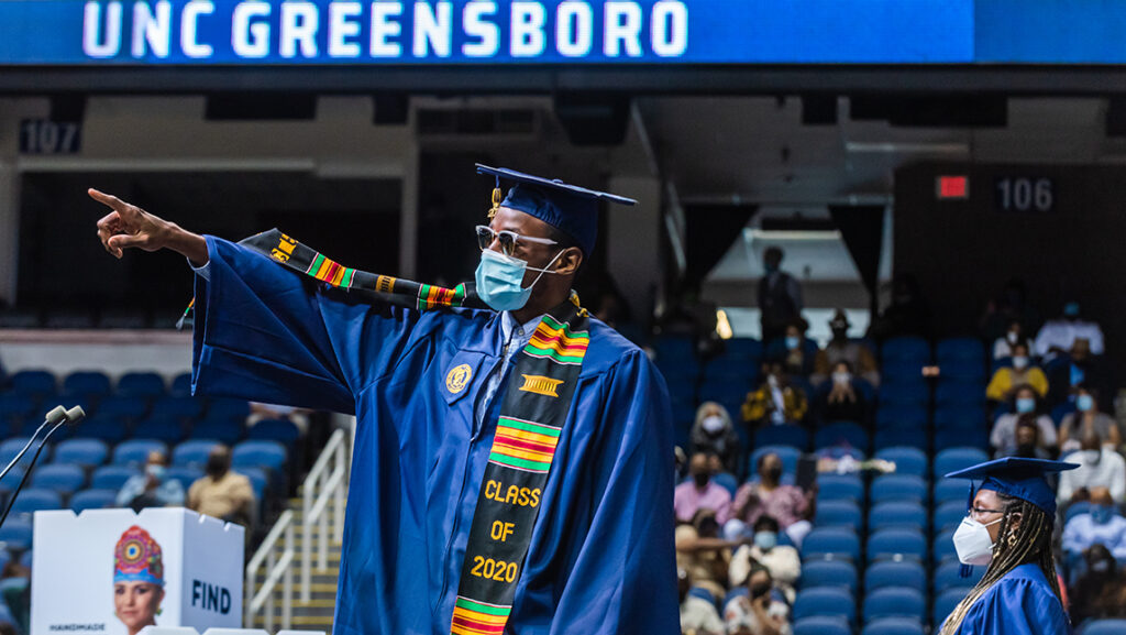 Student pointing to the crowd at commencement