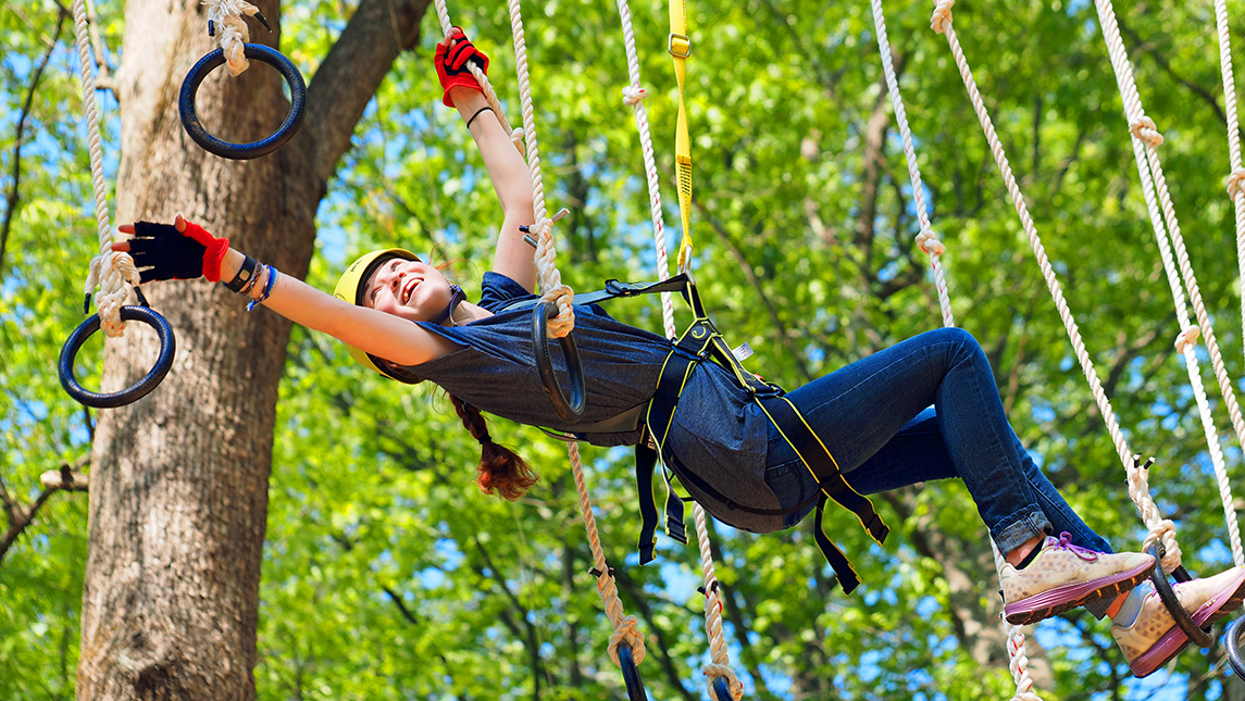 Girl playing in treetop adventure park