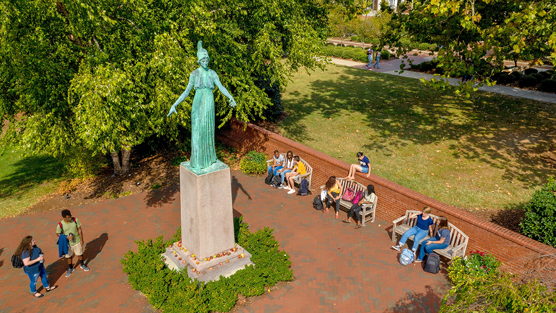 Students sitting on benches around Minerva statue