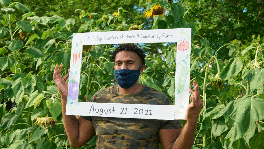 man with sign in sunflower patch