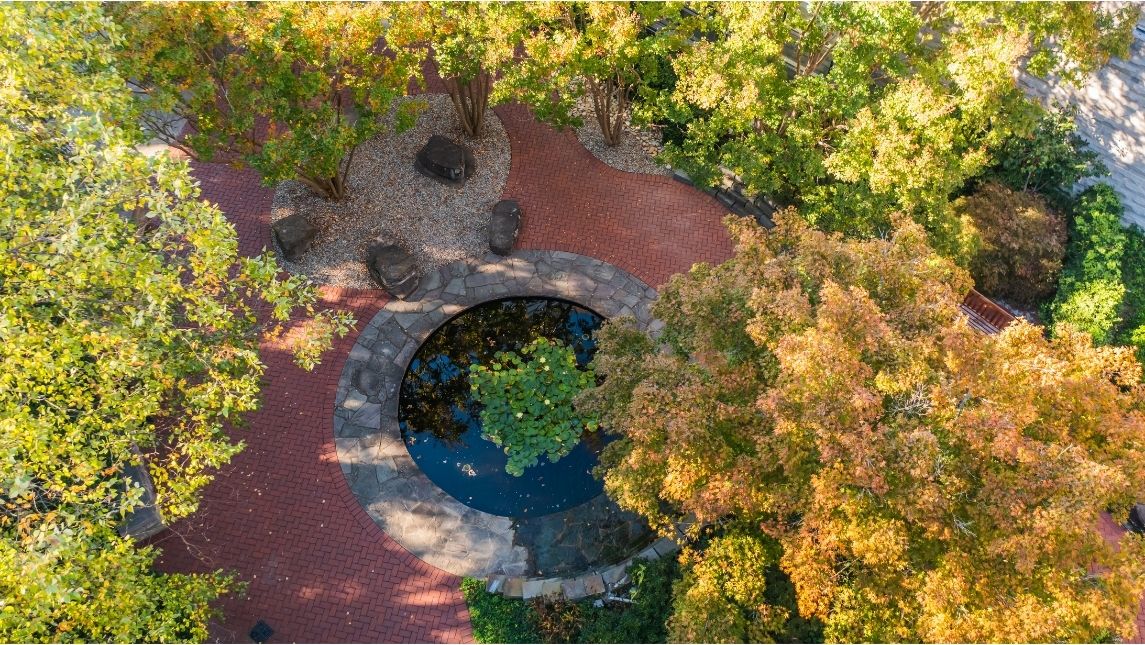 aerial image of a reflection pond surrounded by fall trees