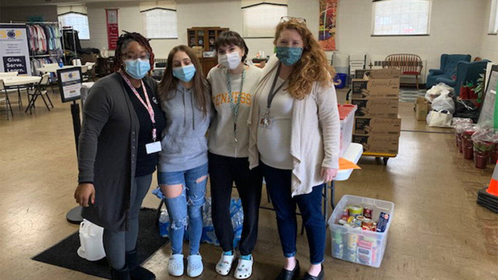 Four women stand in front of Spartan Open Pantry Donation center