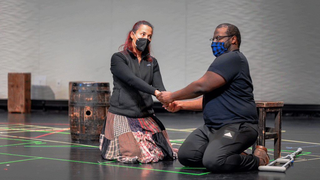 Two actors holding hands
