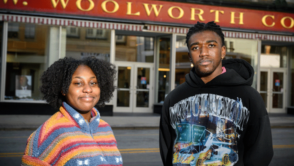 man and woman in front of downtown landmark Woolworths