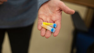 A close-up image of a researcher holding two blood samples in plastic vials.