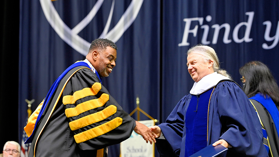 Chancellor Gilliam shaking hands with Dennis Quaintance
