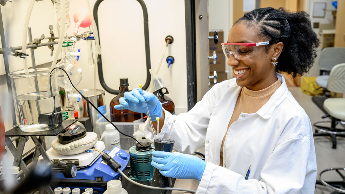 woman in lab in labcoat doing experiments
