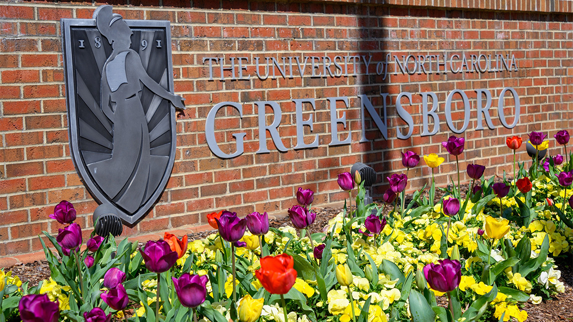 UNCG sign behind flowers