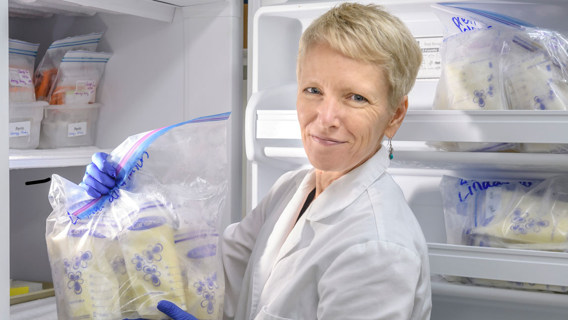 researcher with bags of milk at a fridge