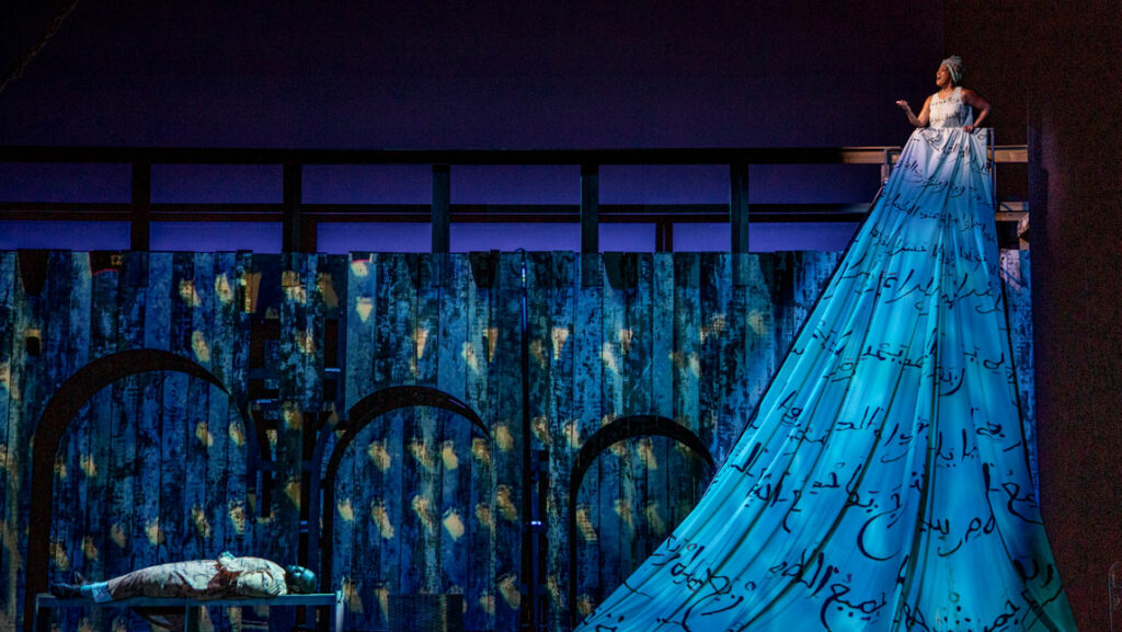 woman in huge dress onstage above reclining man