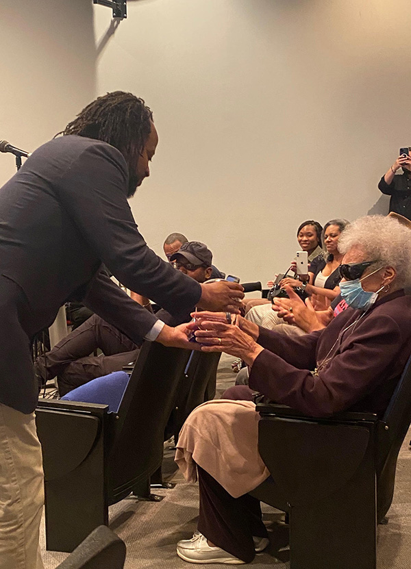 Dr. Armando Collins gives an award to a guest at 2022 Juneteenth Celebration
