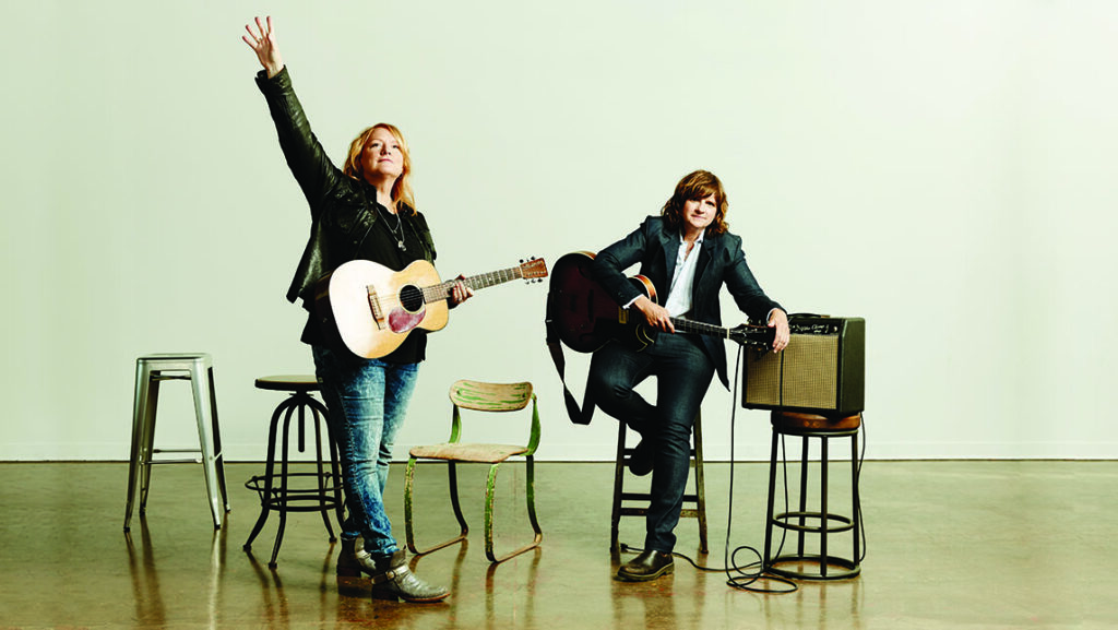 Band Indigo Girls standing with guitars