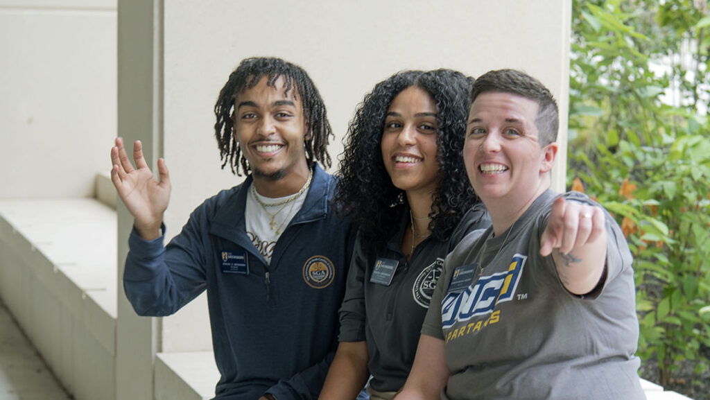 3 UNCG SGA leaders smiling at camera