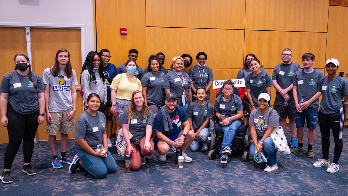 Crowd of students gather around sign reading "Cone Health."